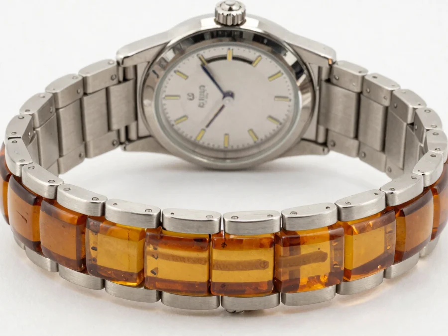 Editorial close-up of a polished steel watch paired with a satura