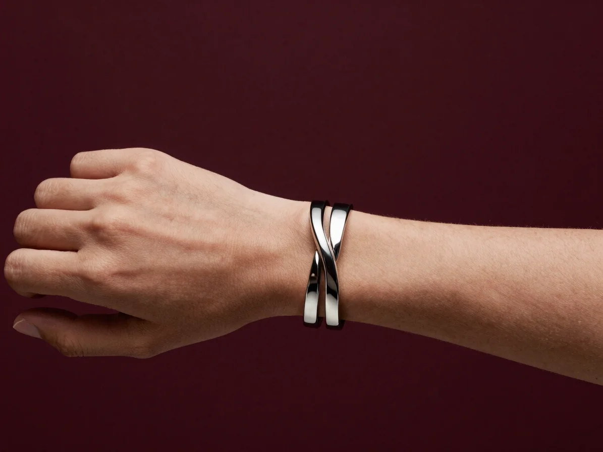 Cropped editorial portrait of a wrist wearing a sculptural metal